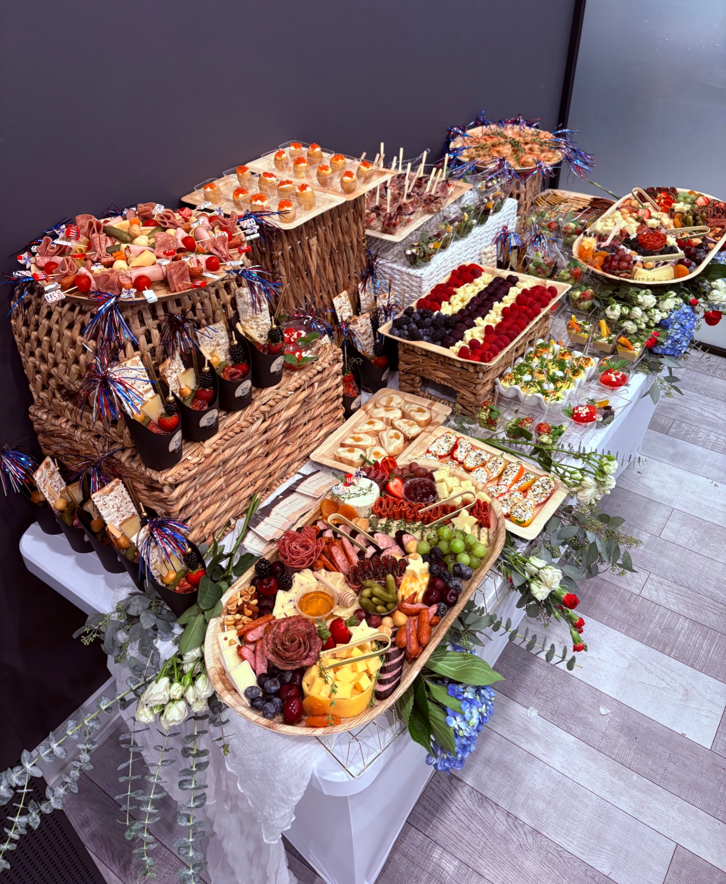 Corporate event grazing setup with charcuterie trays, appetizer cones, and a berry and cheese flag display